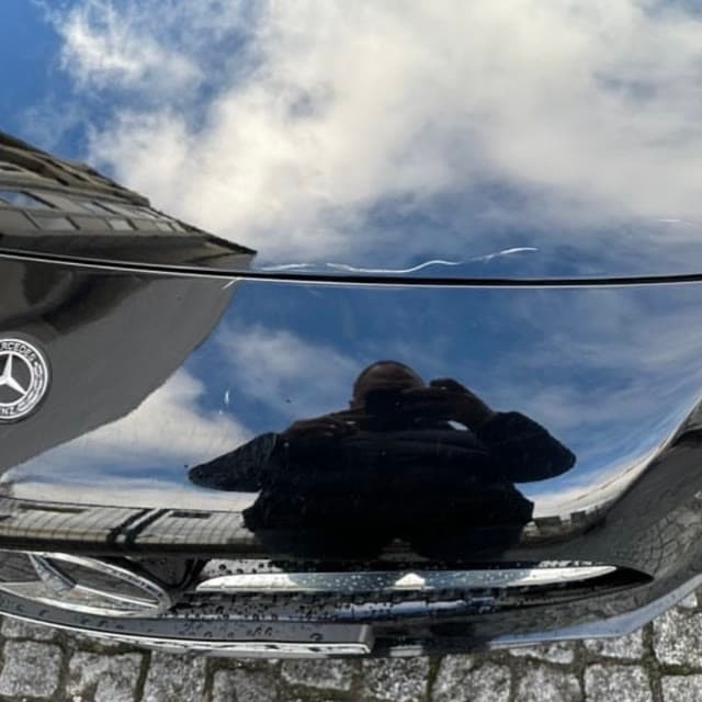 Lackschaden auf der Motorhaube eines schwarzen Mercedes-Benz