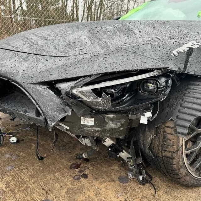 Schwerer Frontschaden an einem grauen Pkw nach einem Unfall, Scheinwerfer und Stoßfänger abgerissen